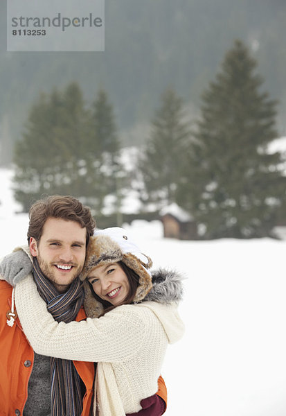 Porträt eines lächelnden Paares im verschneiten Feld