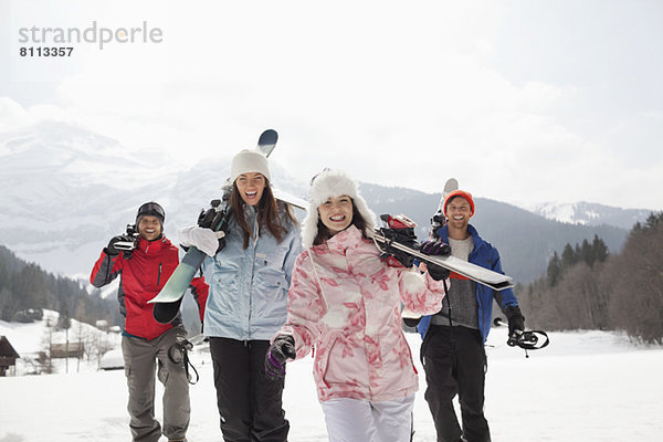 Begeisterte Freunde mit Skiern im Schneefeld