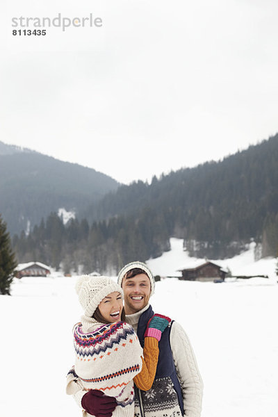Porträt eines glücklichen Paares im verschneiten Feld