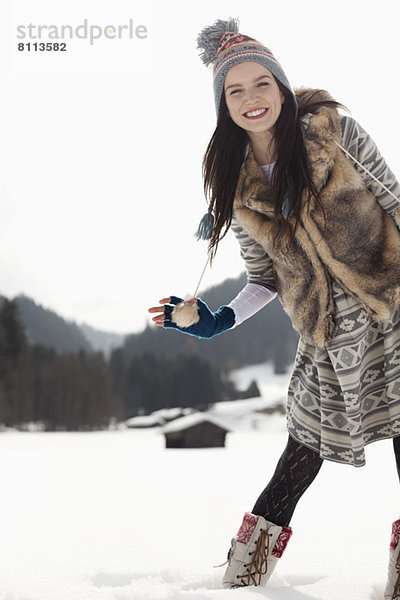 Porträt einer lächelnden Frau im Schneefeld