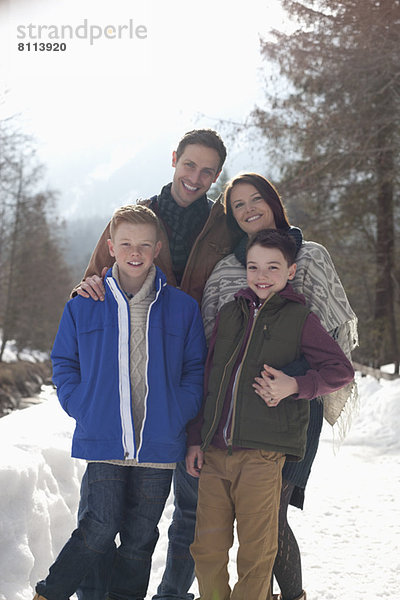 Porträt der lächelnden Familie in der verschneiten Gasse