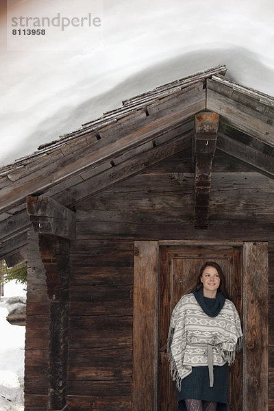 Porträt einer lächelnden Frau  die in der Tür der Schneekabine steht