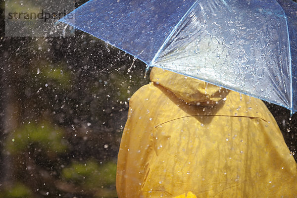 Frau unter Schirm im Regen