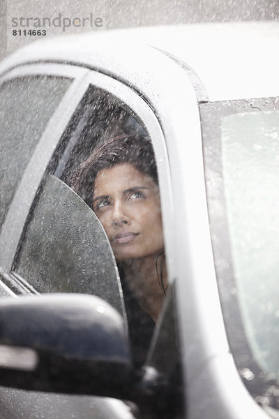 Geschäftsfrau im Auto mit Blick auf den Regen