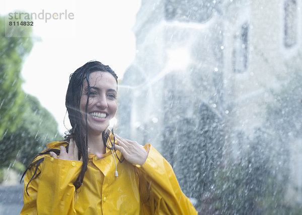 Begeisterte Frau im Regen stehend