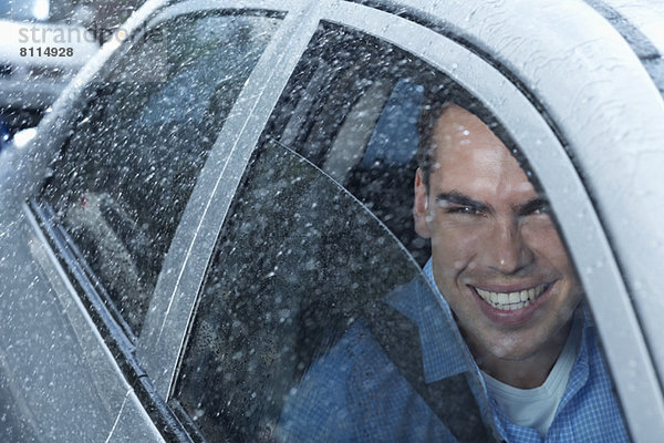 Porträt eines lächelnden Mannes im Auto