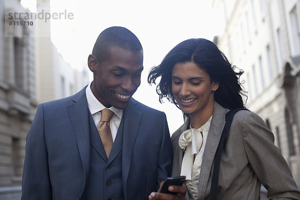 Lächelnde Geschäftsleute SMS mit Handy