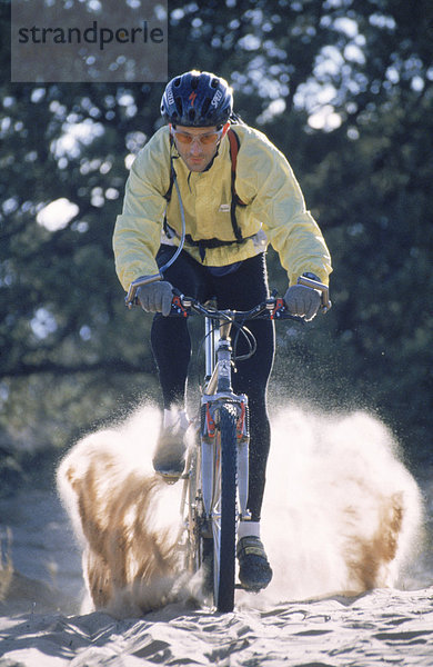 Hochformat  Außenaufnahme  junger Mann  junge Männer  Einzelperson  eine Person  Farbaufnahme  Farbe  Geschwindigkeit  Vereinigte Staaten von Amerika  USA  Tag  fahren  radfahren  Nordamerika  Fotografie  Staub  Mountain-Biking  freie Natur  Sport  Utah