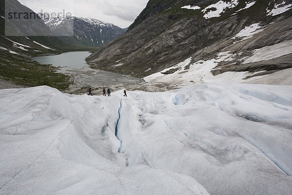 Erhöhte Ansicht  Aufsicht  Außenaufnahme  Landschaftlich schön  landschaftlich reizvoll  Wasser  Wintersport  Textfreiraum  Europa  Berg  Winter  Farbaufnahme  Farbe  Sport  Tag  Freizeit  4  Freiheit  Abenteuer  Forschung  Landschaft  Menschen im Hintergrund  Hintergrundperson  Hintergrundpersonen  See  Querformat  Norwegen  wandern  Gletscher  Fotografie  Kälte  freie Natur  Schnee