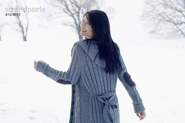 Junge Frau beim Wandern im Schneefeld