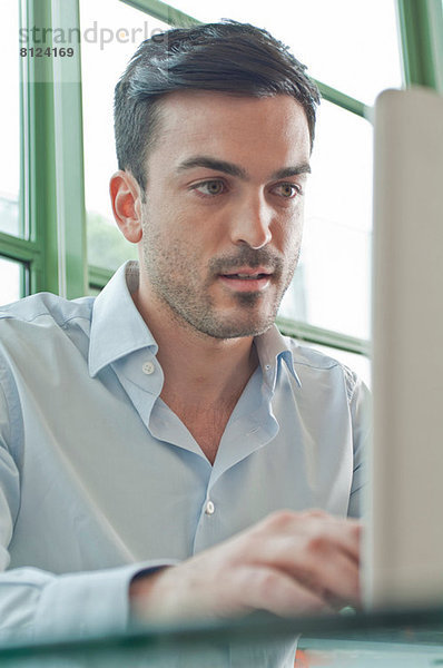 Nahaufnahme von jungen männlichen Büroangestellten mit dem Laptop