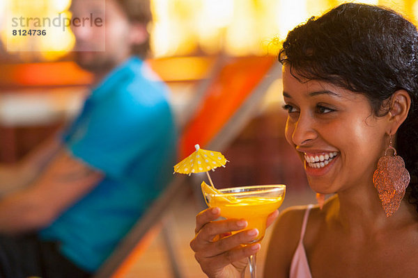 Nahaufnahme einer jungen Frau mit Cocktail auf der Indoor Beach Party