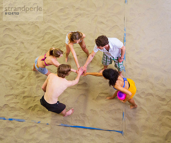 Luftaufnahme von Freunden Teamgespräch beim Indoor Beachvolleyball