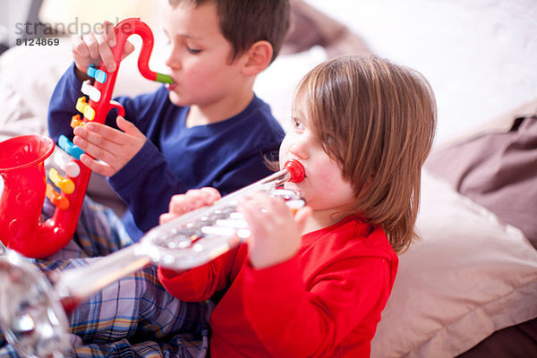 Zwei kleine Kinder beim Spielen von Spielzeuginstrumenten