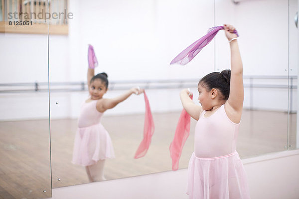 Junge Ballerina tanzt mit rosa Schals