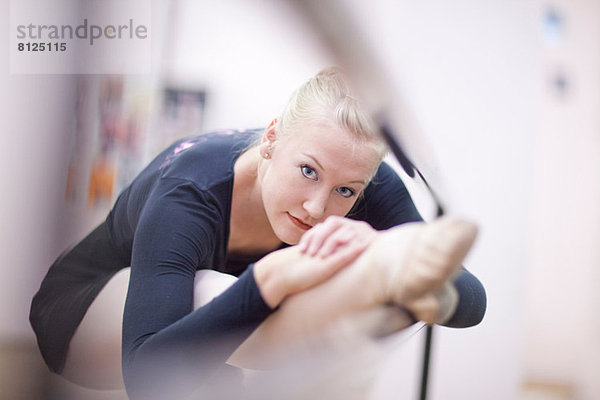 Porträt einer Ballerina  die an der Stange übt.