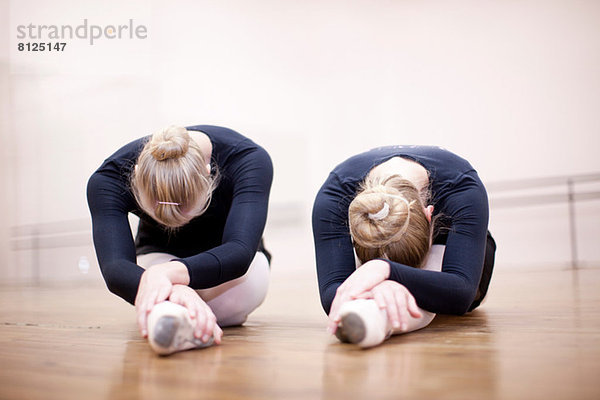 Zwei Ballerinas in Pose auf dem Studioboden