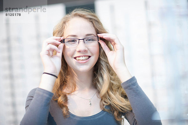 Junge Frau beim Anprobieren einer Brille