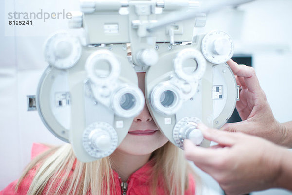 Optiker testet junges Mädchen in der Augenklinik