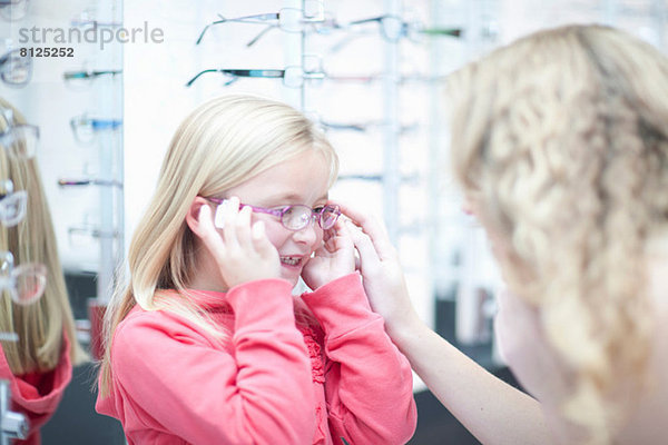 Junges Mädchen beim Anprobieren einer Brille