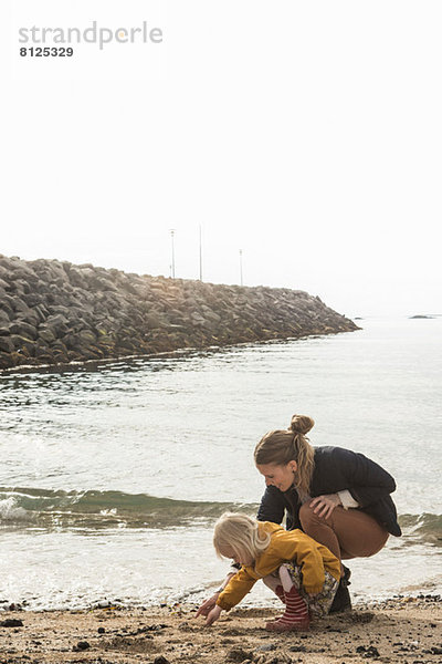 Mutter und Kleinkind bei der Erkundung der Küste