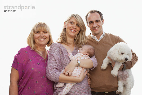 Porträt einer Drei-Generationen-Familie mit neugeborenem Mädchen und Hund