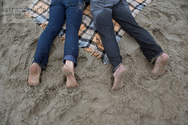 Erwachsenes Paar auf Picknickdecke liegend  hoher Winkel