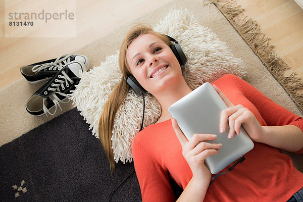 Teenager Mädchen mit Kopfhörer und digitalem Tablett