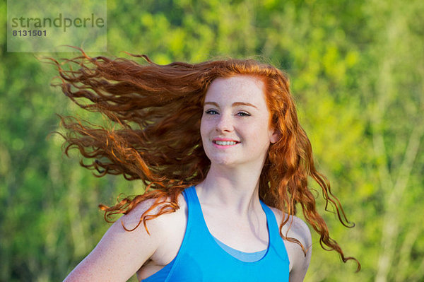 Porträt eines jungen Mädchens mit langen roten Haaren
