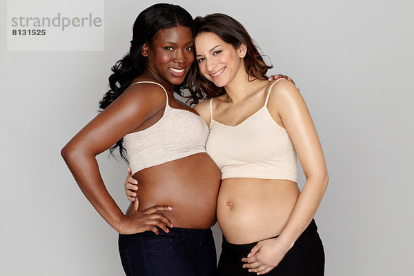 Zwei schwangere Frauen  die sich umarmen.