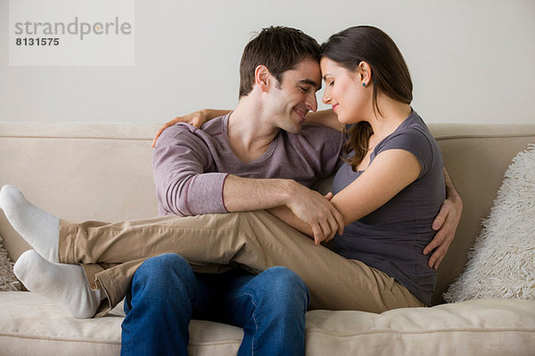 Paar auf Sofa  Frau sitzt auf dem Schoß des Mannes