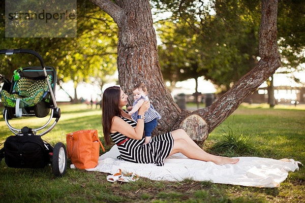 Mutter sitzend auf Picknickdecke mit Baby-Tochter