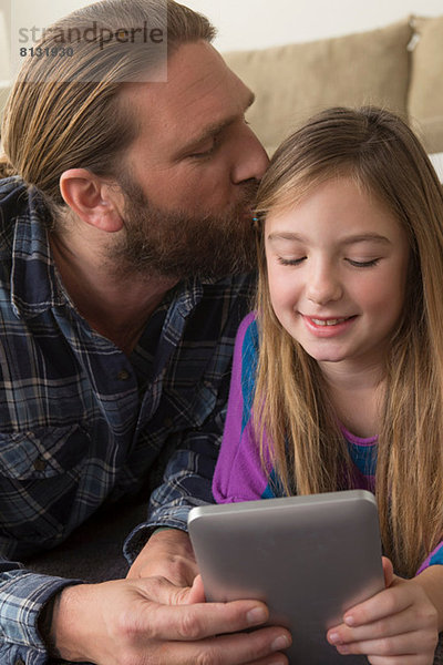 Mädchen beim Betrachten des digitalen Tabletts mit Vater