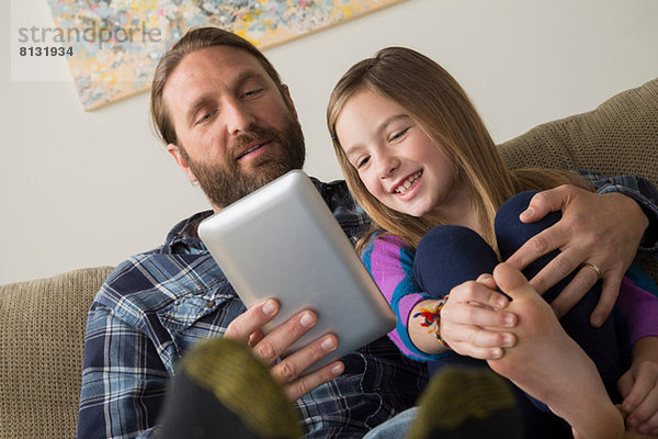 Vater und Tochter beim Betrachten des digitalen Tabletts
