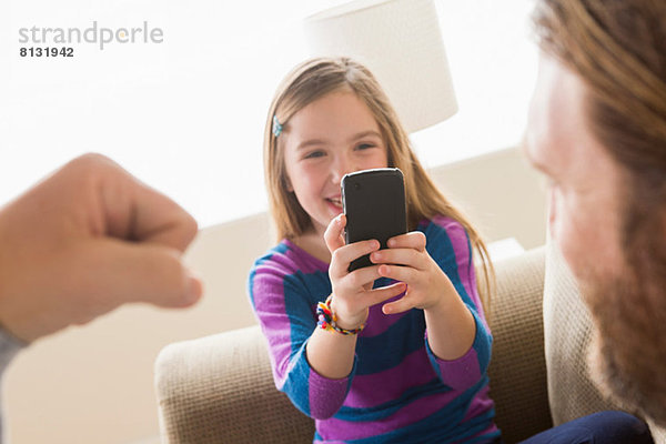 Tochter fotografiert Vater mit Smartphone