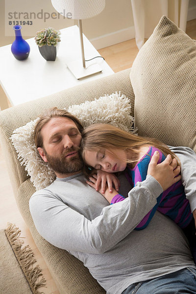 Vater und Tochter schlafen auf der Couch