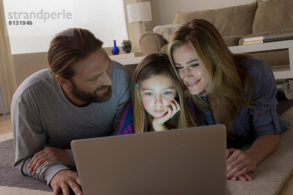 Eltern und Kind schauen auf den Laptop