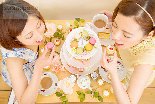 Zwei glückliche Frauen  die in süßen Kuchen schwelgen.
