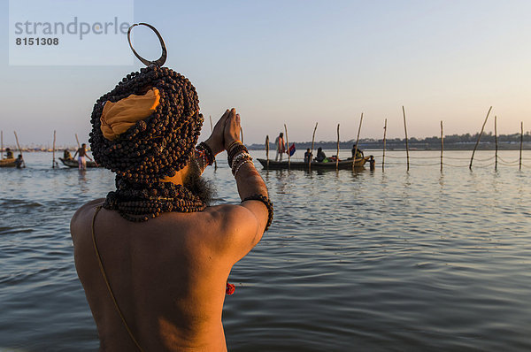 Sadhu  heiliger Mann  betend beim Bad am Sangam  dem Zusammenfluss Ganges  Yamuna und Saraswati  kurz vor Sonnenuntergang  Kumbha Mela  hinduistische Massenwallfahrt