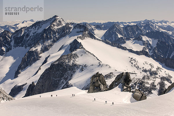 Bergsteiger steigen über ein Gletscherfeld zum Gipfel des Schwarzenstein auf