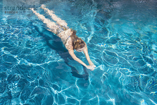 Junge Frau schwimmt im Pool