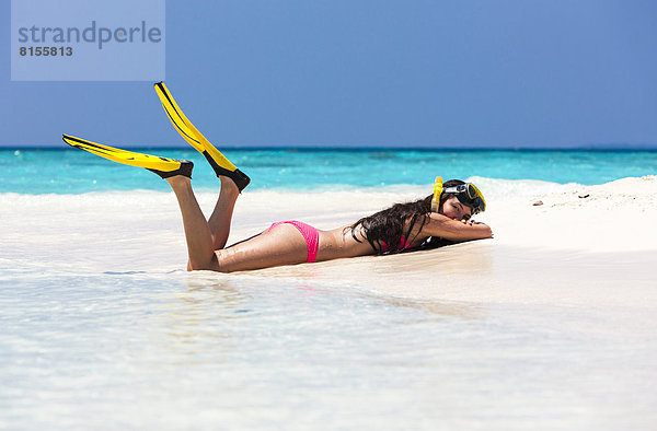 Malediven Junge Frau am Strand liegend