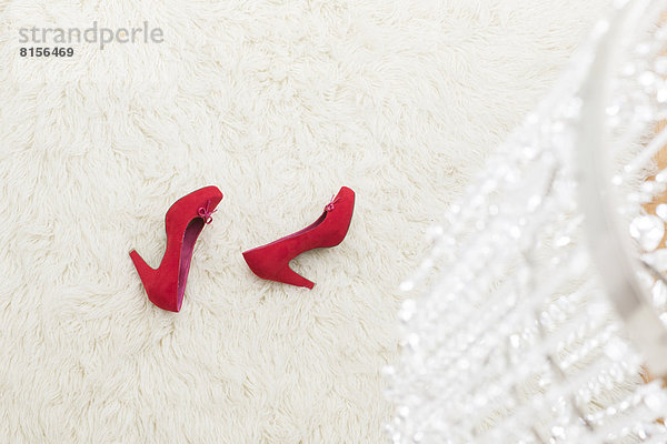 Red High Heels laying on white carpet