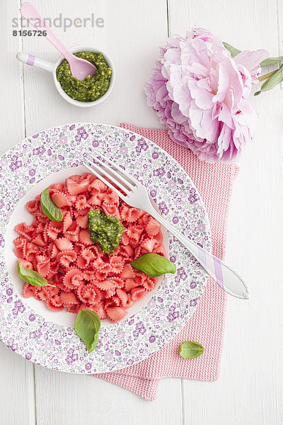 Hausgemachte rosa Nudeln mit Basilikum und Pesto auf dem Teller