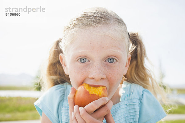 Außenaufnahme  Europäer  Frucht  essen  essend  isst  Mädchen  freie Natur
