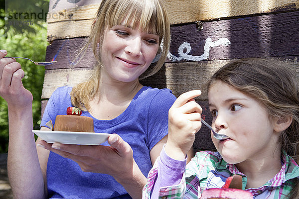 Deutschland  Nordrhein-Westfalen  Köln  Mutter und Tochter essen Kuchen  lächeln