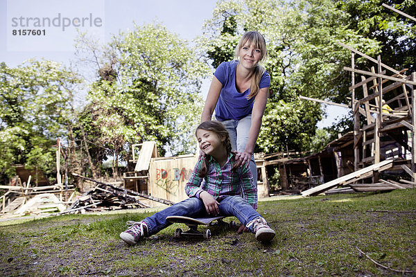 Deutschland  Nordrhein-Westfalen  Köln  Mutter und Tochter spielen mit Skateboard  lachend