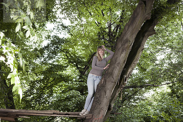 Deutschland  Nordrhein-Westfalen  Köln  Junge Frau auf Holz stehend