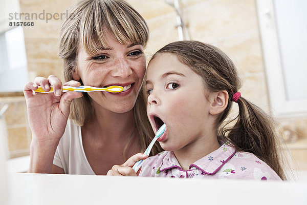 Deutschland  Nordrhein-Westfalen    Mutter und Tochter beim Zähneputzen im Bad