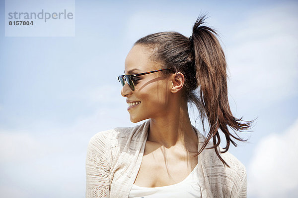 Deutschland  Junge Frau mit Sonnenbrille  lächelnd